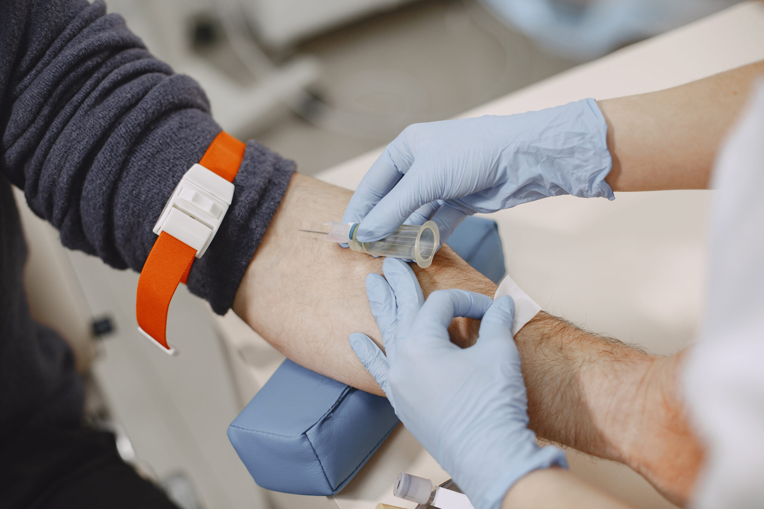nurse taking blood sample from patient at the doctors office